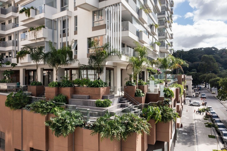 Fachada do edifício Highlight em Botafogo, com jardineiras revestidas em cumaru e palmeiras emergindo entre os pavimentos.